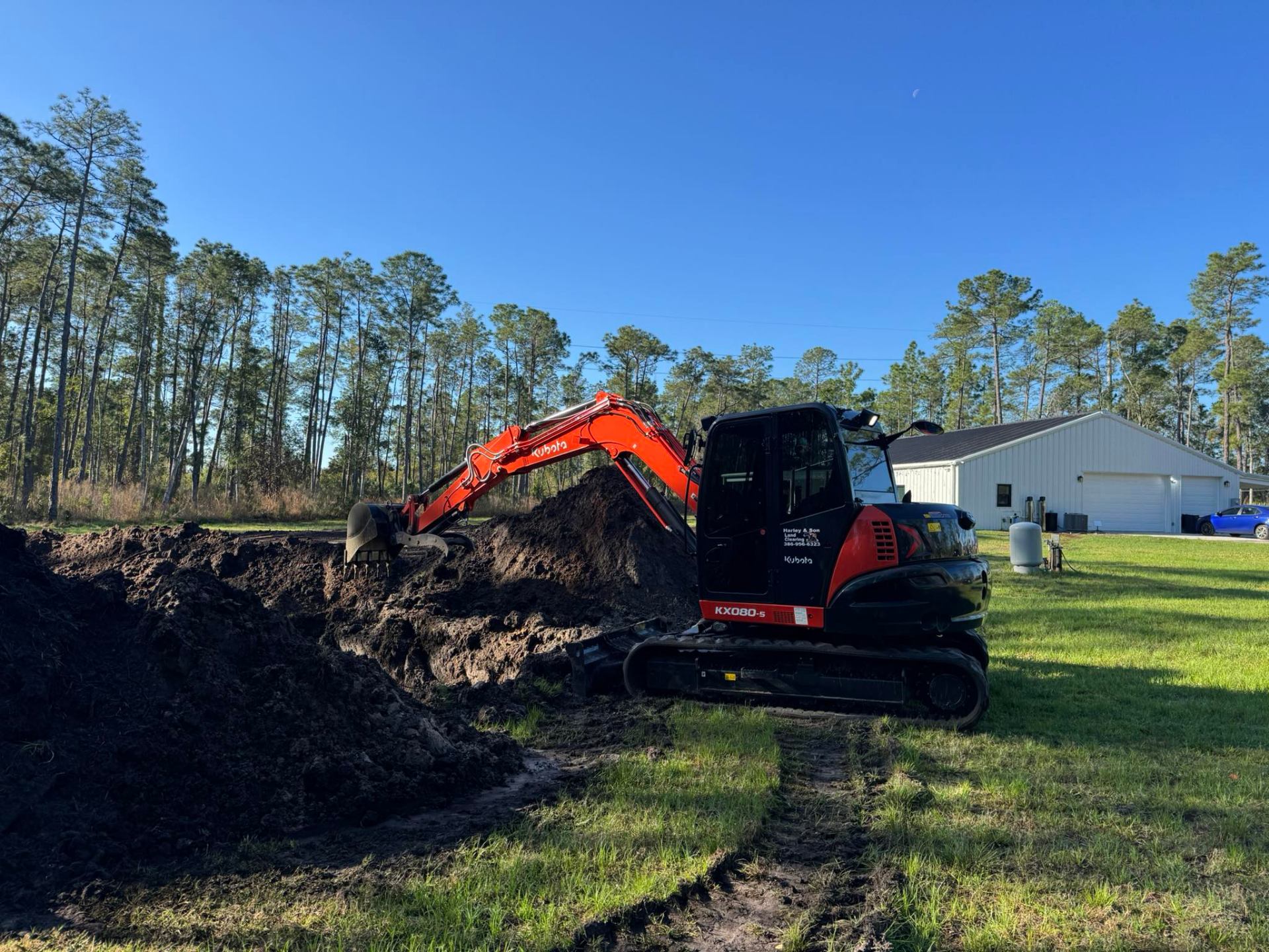 Kubota KX080 excavator digging dirt on a job site in Deltona, Florida