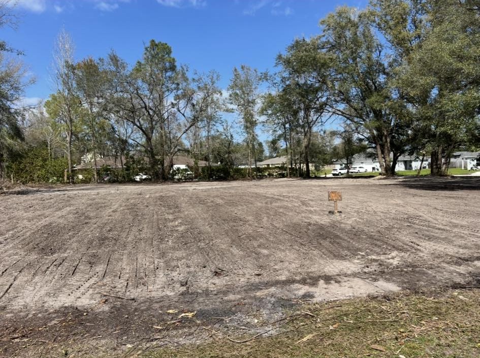 Freshly cleared lot in residential neighborhood with mature oaks preserved in Volusia County