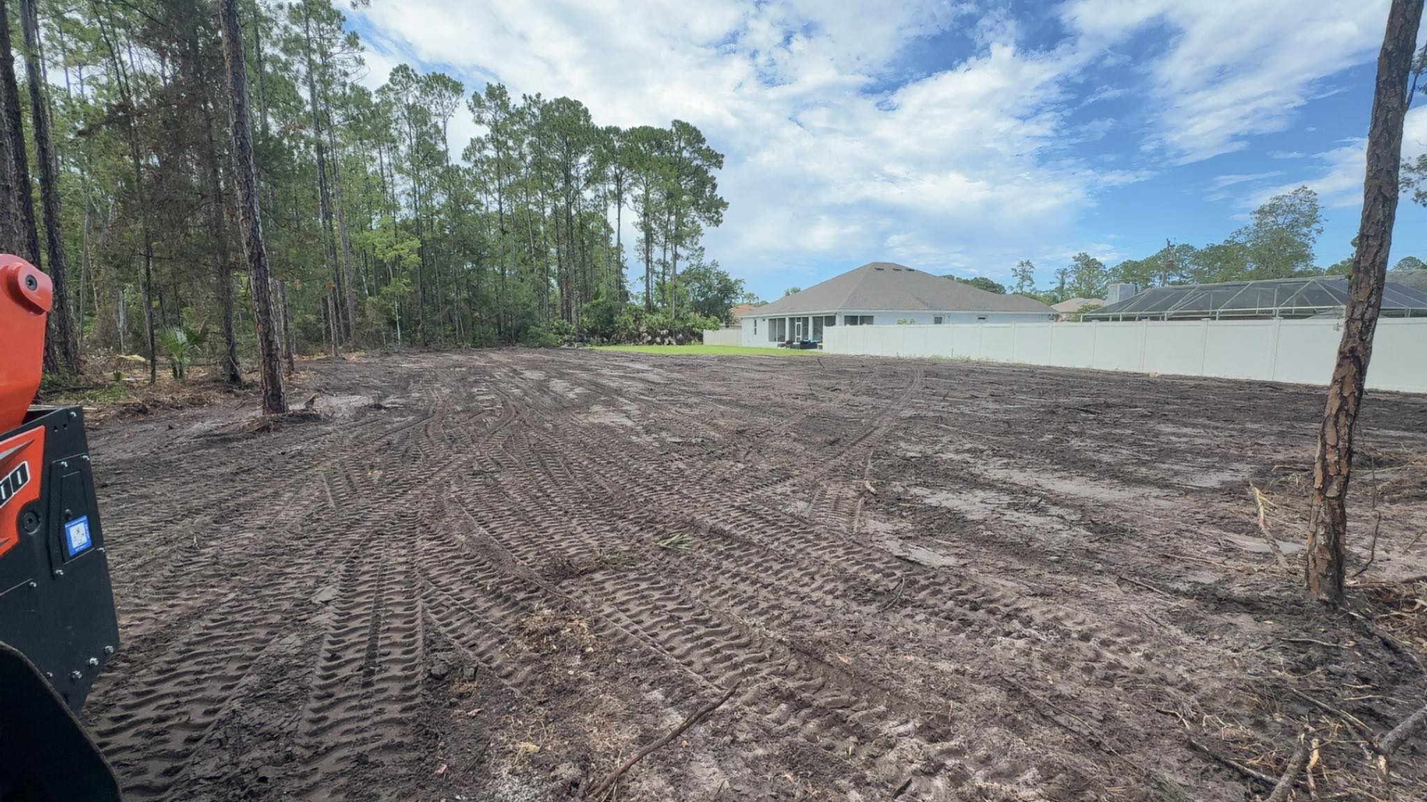 Kubota skid steer on freshly cleared residential lot after debris removal in Deltona, FL